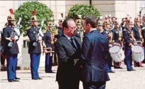  ?? AP PIC ?? French President Emmanuel Macron bidding farewell to outgoing president Francois Hollande as the latter leaves Elysee Palace after the handover ceremony in Paris yesterday.