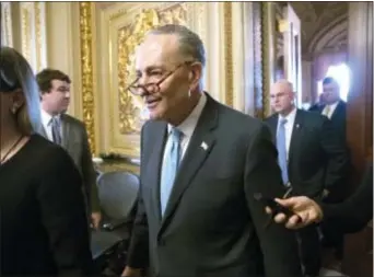  ?? J. SCOTT APPLEWHITE — THE ASSOCIATED PRESS ?? Senate Minority Leader Chuck Schumer, D-N.Y., heads to the chamber with fellow Democrats for a procedural vote aimed at reopening the government, at the Capitol Washington, Monday. in