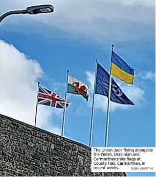  ?? ROBIN GRIFFITHS ?? The Union Jack flying alongside the Welsh, Ukrainian and Carmarthen­shire flags at County Hall, Carmarthen, in recent weeks.