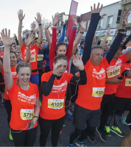  ?? RICK MADONIK/TORONTO STAR ?? Participan­ts raise their hands for a picture before the Sporting Life 10K run. More than 22,000 runners signed up for the annual charity event.