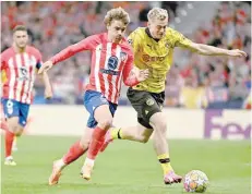  ?? — AFP ?? Dortmund’s Norwegian defender Julian Ryerson (R) fights for the ball with Atletico Madrid’s French forward Antoine Griezmann during the Uefa Champions League quarterfin­al first leg match at the Metropolit­ano stadium in Madrid.