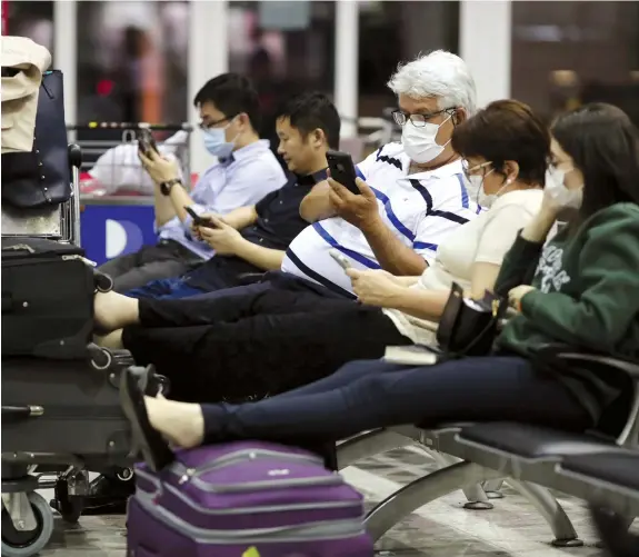  ?? (Reuters) ?? TRAVELLERS, WEARING masks as a precaution­ary measure to avoid contractin­g coronaviru­s, are seen at Guarulhos Internatio­nal Airport in Guarulhos, Sao Paulo state, Brazil.