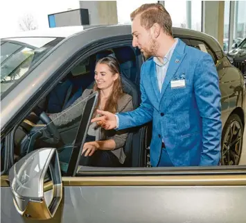  ?? Foto: Peter Fastl ?? Anna Maria Barisch (BMW Reisacher) lässt sich vom ehemaligen Auszubilde­nden Johannes Seibold die Besonderhe­iten des neuen BMW erklären.