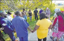  ?? John Raoux
The Associated Press ?? Residents gather for a prayer near the scene of a mass shooting at a Dollar General store on Saturday in Jacksonvil­le, Fla. Three people were killed before the gunman killed himself.