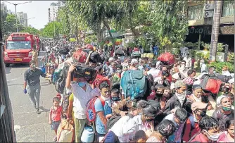  ?? PRAMOD THAKUR/HT ?? Migrants gather outside Oshiwara police station to board buses to various stations to return to their hometowns, on Tuesday.