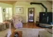  ??  ?? A wood-burning stove sits on a stone platform in the family room, along with a French door walkout.