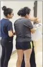  ?? Westside Eagle Observer/MIKE ECKELS ?? Two students look over the new year book with their mother in the hallway at Decatur High School during the district’s open house Aug. 11.