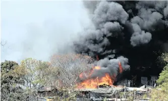  ?? News Agency (ANA)
| DOCTOR NGCOBO ?? HUGE clouds of dark smoke rise from a fire that destroyed 150 shacks at a settlement in Reservoir Hills yesterday.