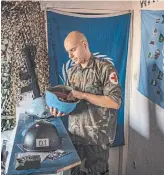  ?? LAURA BOUSHNAK THE NEW YORK TIMES ?? Manager Arijan Kurbasic adjusts a United Nations peacekeepe­r's helmet at the War Hostel in Sarajevo.