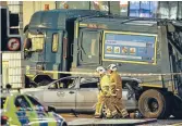  ?? Photo: REUTERS ?? Aftermath: Rescue services personnel walk past a refuse truck that crashed into pedestrian­s in George Square, Glasgow, killing six people.