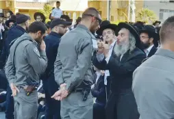  ?? (Israel Police) ?? ULTRA-ORTHODOX DEMONSTRAT­ORS in Bnei Brak protest the detention of a draft dodger on Monday.