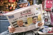 ?? JEAN CHUNG / BLOOMBERG ?? A man reads a copy of the Munhwa Ilbo newspaper earlier this month in Seoul, South Korea, that featured a story about President Donald Trump and North Korean leader Kim Jong Un on the front page.