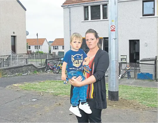  ?? Picture: Gareth Jennings. ?? Sarah Watt with her son Adam, who was burned by creosote, in front of the new metal pole at their home.