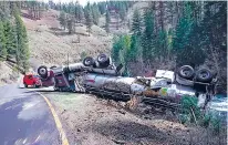  ?? OREGON DEPARTMENT OF FISH AND WILDLIFE VIA THE WASHINGTON POST ?? A fish tanker truck carrying 102,000 spring Chinook smolts is overturned along Lookinggla­ss Creek in northeast Oregon. The truck slid down the rocky embankment, emptying the majority of its cargo into the creek.