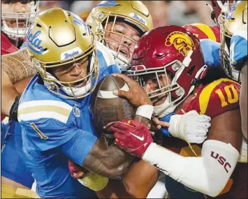  ?? MARK J. TERRILL / AP FILE (2022) ?? UCLA quarterbac­k Dorian Thompson-robinson (1) heads in for a touchdown as USC linebacker Ralen Goforth (10) tries to stop him during the crosstown rivals’ 2022 game in Pasadena, Calif. With the Trojans and Bruins in tow, the Pac-12’s renegotiat­ed TV deal could have placed the league an easy third behind the Big Ten and SEC. Without the Los Angeles schools, though, that no longer is the case.