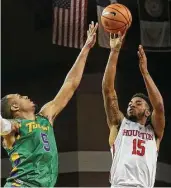  ?? Yi-Chin Lee / Chronicle ?? Houston’s Devin Davis, who finished with a game-high 16 points, shoots over Tulane’s Cameron Reynolds during the first half of UH’s victory over the Green Wave at H&PE Arena on Sunday.