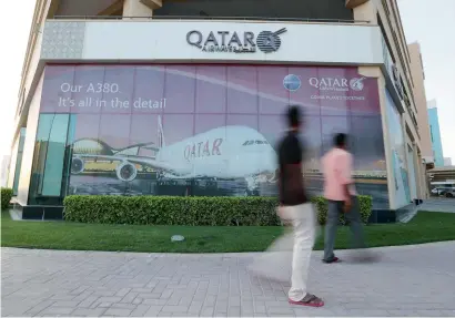  ?? Reuters ?? People walk past the Qatar Airways office in Manama, Bahrain. The UAE, Saudi Arabia, Bahrain and Egypt have placed a ban on Qatar Airways’ use of airspace belonging to the countries. —