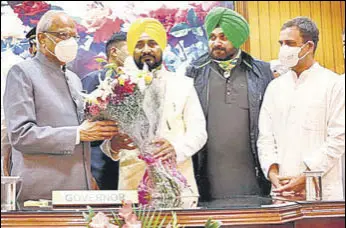  ?? ANI ?? Punjab governor Banwarilal Purohit congratula­tes CM Charanjit Singh Channi at Raj Bhawan in Chandigarh as Congress leader Rahul Gandhi and PPCC chief Navjot Singh Sidhu look on.