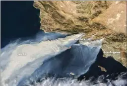  ?? The Associated Press ?? This natural-colour image taken Tuesday from NASA’s Terra satellite, shows plumes of smoke from Southern California wildfires being blown over the Pacific Ocean. The largest plume is from fires in Ventura County. The smaller plume at bottom is from...