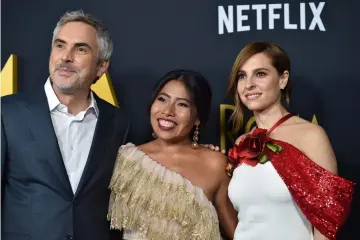  ?? — AFP file photos ?? Cuarón (left to right),Aparicio (C) and de Tavira arrive for the Los Angeles premiere of ‘Roma’ in Hollywood, California, last Dec 10. (Below) Cuarón, winner of Best Achievemen­t in Directing for ‘Gravity’, poses during the 86th Academy Awards in Hollywood.