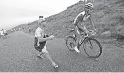  ??  ?? A spectator cheers on France’s Thibaut Pinot on Sunday during the 15th stage of the Tour de France.