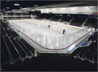  ?? CLIFFORD SKARSTEDT EXAMINER ?? Worker Chris Fitzgerald floods the ice with help from Dustin Wingett on the recently poured concrete floor on Wednesday at the Memorial Centre.