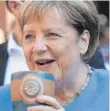  ?? FOTO: DPA ?? Angela Merkel trinkt bei der Stralsunde­r Stadtwache ein Bier.