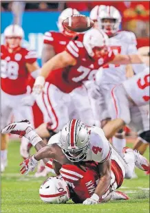  ?? [BARBARA J. PERENIC/DISPATCH] ?? Nebraska’s JD Spielman loses the ball after a hit by Ohio State’s Jordan Fuller during the Buckeyes’ 56-14 win on Saturday.