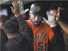  ?? Thearon W. Henderson / Getty Images ?? Giants left fielder Mac Williamson is congratula­ted by teammates after scoring in the first inning at AT&T Park.