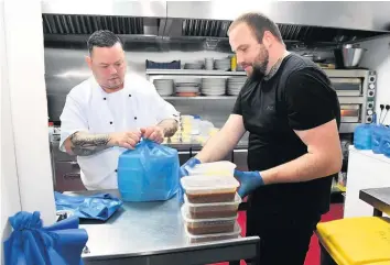  ??  ?? Boxing clever
Legends chef Lee Brannigan and bartender Andrew Dorman pack up the meals for delivery