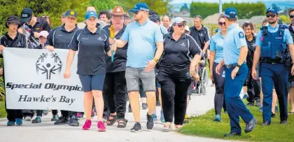  ?? Photo / Supplied ?? McKenzie Donaldson and Constable Mike Hunter holding the torch and leading the walk around the Hawke’s Bay Regional Sports Park in Hastings.