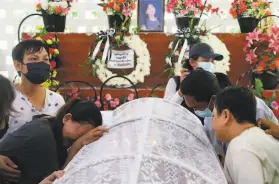  ?? Associated Press ?? People mourn at a funeral in Yangon for a woman who was killed during a demonstrat­ion against the coup that ousted Myanmar’s elected leaders.