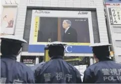  ??  ?? 0 Policemen watch the ceremony while on guard duty in Tokyo