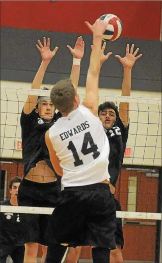  ?? GENE WALSH — DIGITAL FIRST MEDIA ?? Pennridge’s Cross Edwards spikes as Upper Dublin’s Alec Madden and Blake Bayles defend Monday night.