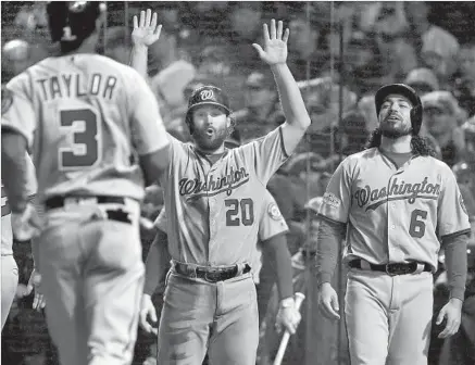  ?? Jonathan Daniel Getty Images ?? MICHAEL A. TAYLOR is greeted by Daniel Murphy (20) and Anthony Rendon (6) after hitting a grand slam in the eighth inning.