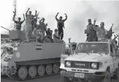  ?? — AFP ?? Iraqi soldiers wave to a humanitari­an aid convoy en route to Amerli, Iraq, on Sunday.