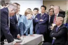  ?? JESCO DENZEL/GERMAN FEDERAL GOVERNMENT VIA AP ?? In this photo made available by the German Federal Government, German Chancellor Angela Merkel, center, speaks with U.S. President Donald Trump, seated at right, during the G7 Leaders Summit in La Malbaie, Quebec, Canada, on Saturday, June 9, 2018.