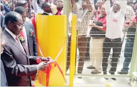  ??  ?? President Mugabe cuts a ribbon to officially open the PPC Harare plant while other guests look on in Msasa yesterday (Picture by Believe Nyakudjara)