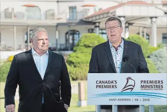  ?? ANDREW VAUGHAN/THE CANADIAN PRESS ?? Ontario Premier Doug Ford, left, and Saskatchew­an Premier Scott Moe talk with reporters as the Canadian premiers meet in St. Andrews, N.B. on July 19 after agreeing to fight the federal government plan to impose a carbon tax.