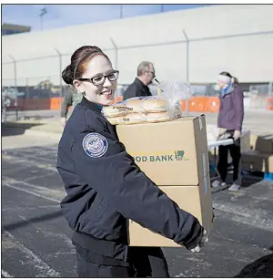  ?? NWA Democrat-Gazette/CHARLIE KAIJO ?? Transporta­tion Security Administra­tion screener Terisa Flippin carries boxes of donated food Friday at Northwest Arkansas Regional Airport in Highfill.