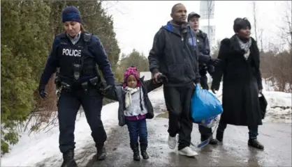  ?? PAUL CHIASSON, THE CANADIAN PRESS ?? A family of asylum claimants is taken into custody after crossing the border into Canada from the United States on Tuesday.