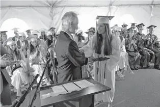  ??  ?? TOP: Desert Academy’s Terry Passalacqu­a, head of school, hands Hailey Sophia Zimmer her diploma during the 2017 graduation ceremony Wednesday.