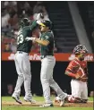  ?? JAE C. HONG — ASSOCIATED PRESS ?? Matt Olson, center, celebrates his three-run home run with Matt Joyce as the A’s unloaded on the Angels for eight runs in the fourth inning.