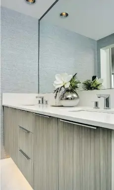  ??  ?? Bathrooms feature “floating” vanities with soft-close cabinets.