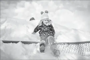  ?? Herald photo by Tijana Martin ?? Madelynn Turner, 4, slides down the giant snow pile at Fleetwood Bawden School on Tuesday afternoon. @TMartinHer­ald