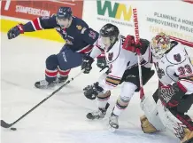  ?? JIM WELLS//POSTMEDIA ?? Hitmen defender Jake Bean scrambles out of his own end in front of goalie Kyle Dumba and the Regina Pats’ Jeff de Wit during WHL playoff action at the Scotiabank Saddledome on Tuesday night.