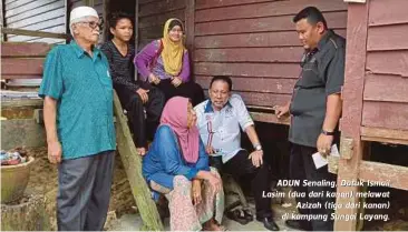  ??  ?? ADUN Senaling, Datuk Ismail Lasim (dua dari kanan) melawat
Azizah (tiga dari kanan) di kampung Sungai Layang.