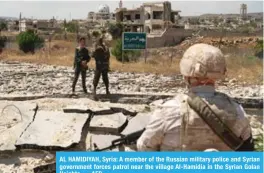  ?? — AFP ?? AL HAMIDIYAH, Syria: A member of the Russian military police and Syrian government forces patrol near the village Al-Hamidia in the Syrian Golan Heights.