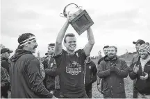  ?? SUBMITTED PHOTO ?? Ryan Lloyd lifts the Caledonia Cup after the Hunter’s Corner Mudmen RFC won the Maritime Division 1 championsh­ip in October at UPEI.