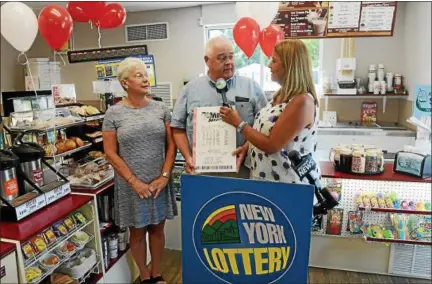  ?? TANIA BARRICKLO — DAILY FREEMAN ?? Robert and Anne Burhans talk with New York Lottery’s Yolanda Vega about winning $1,000,000 win at the Stewart’s Shop at 268 Broadway in Kingston, N.Y., where he purchased the ticket.Online: A video appears with this story at